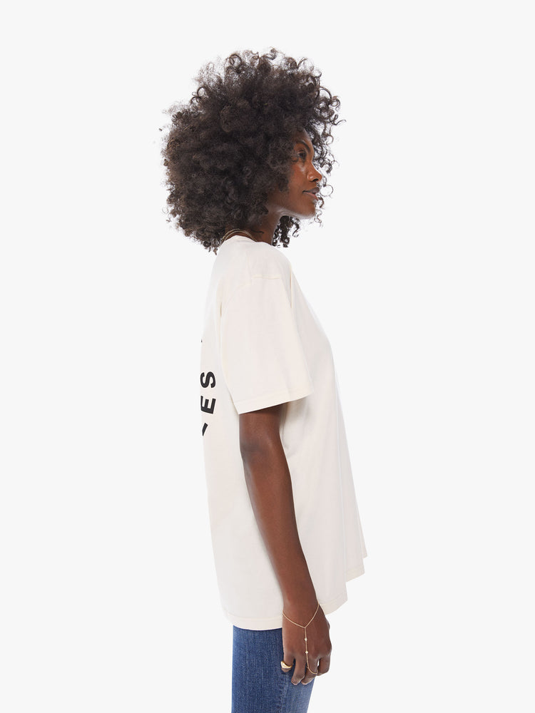 Side view of a women's ecru crew neck tee featuring an oversized fit.