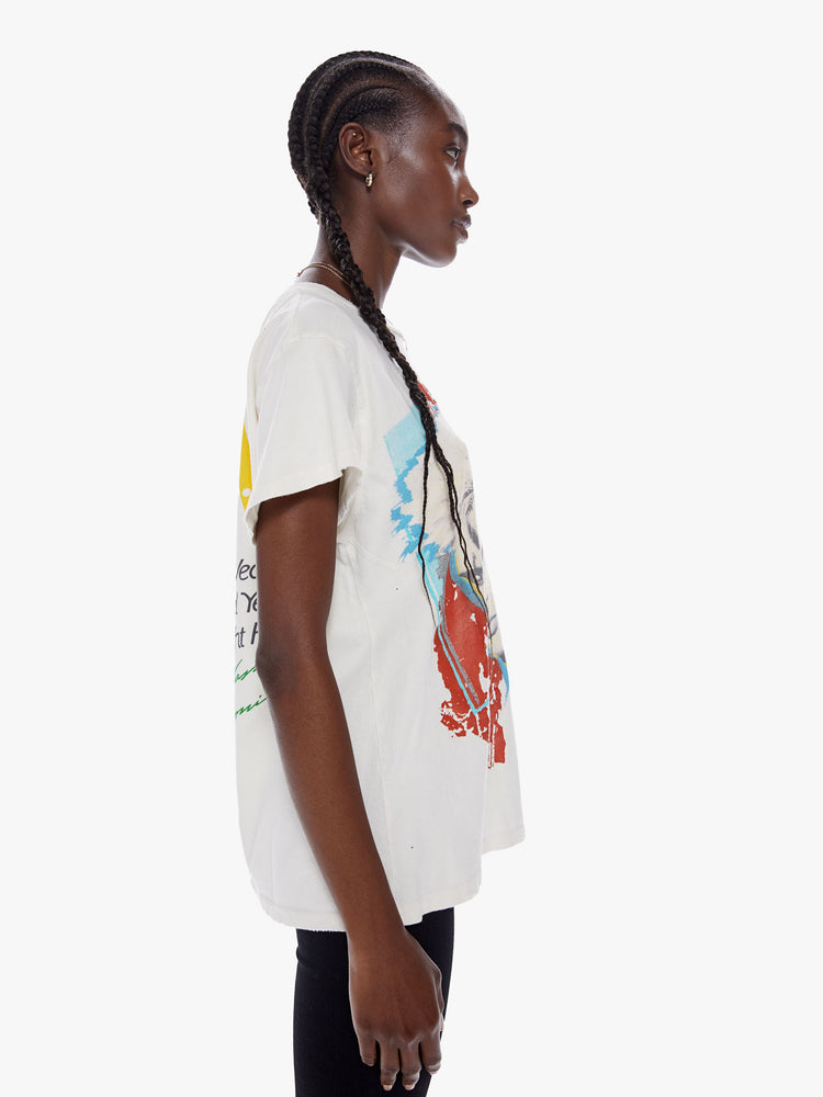 Side view of a woman wearing an off white crew neck tee featuring a large Billy Idol graphic and an oversized fit.