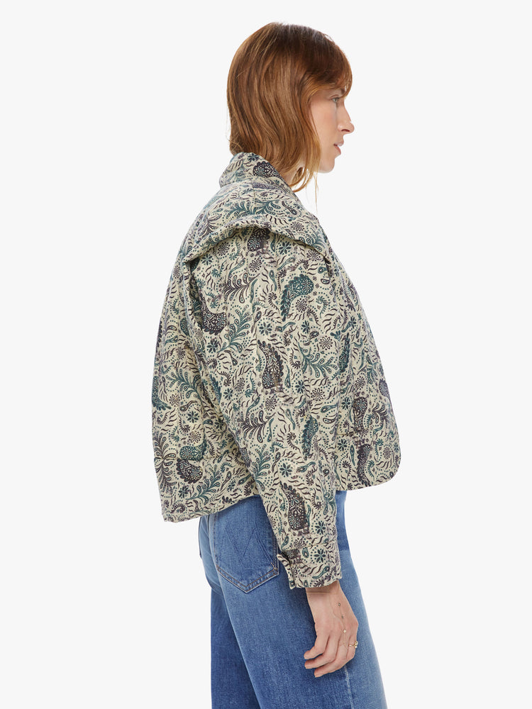 Side view of a woman wearing a cropped jacket featuring a neutral paisley print, a boxy fit, and dropped overlap shoulders.