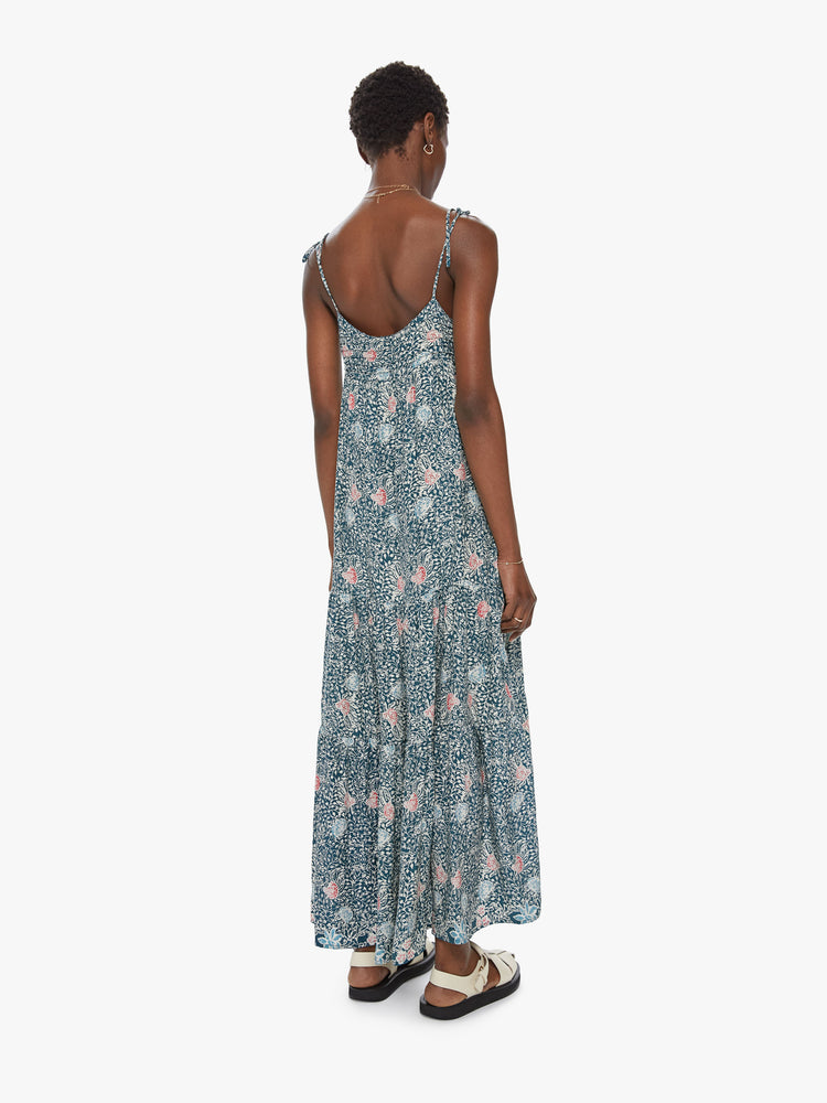 Back view of a spaghetti strap dress featuring a long, flowy fit and a green floral print.