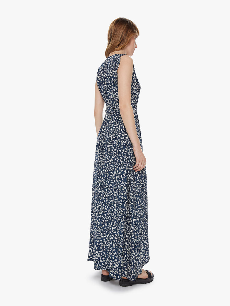Back view of a sleeveless wrap dress featuring a long, flowy fit and an indigo floral print.