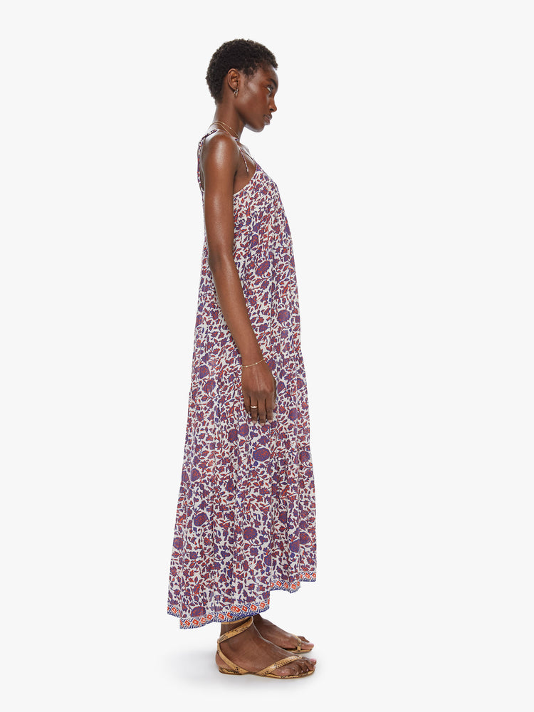 Side view of a spaghetti strap dress featuring a long, flowy fit and a blue and red floral print.