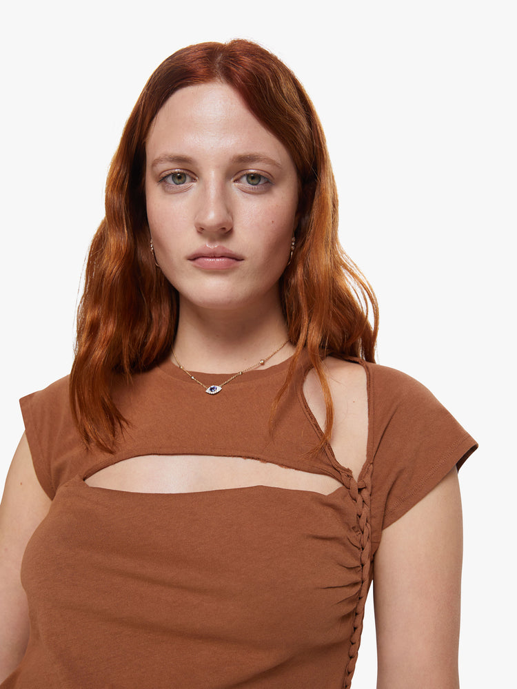 Front close up view of a womens fitted crew neck tee in brown featuring a chest and shoulder cutout and braided details.