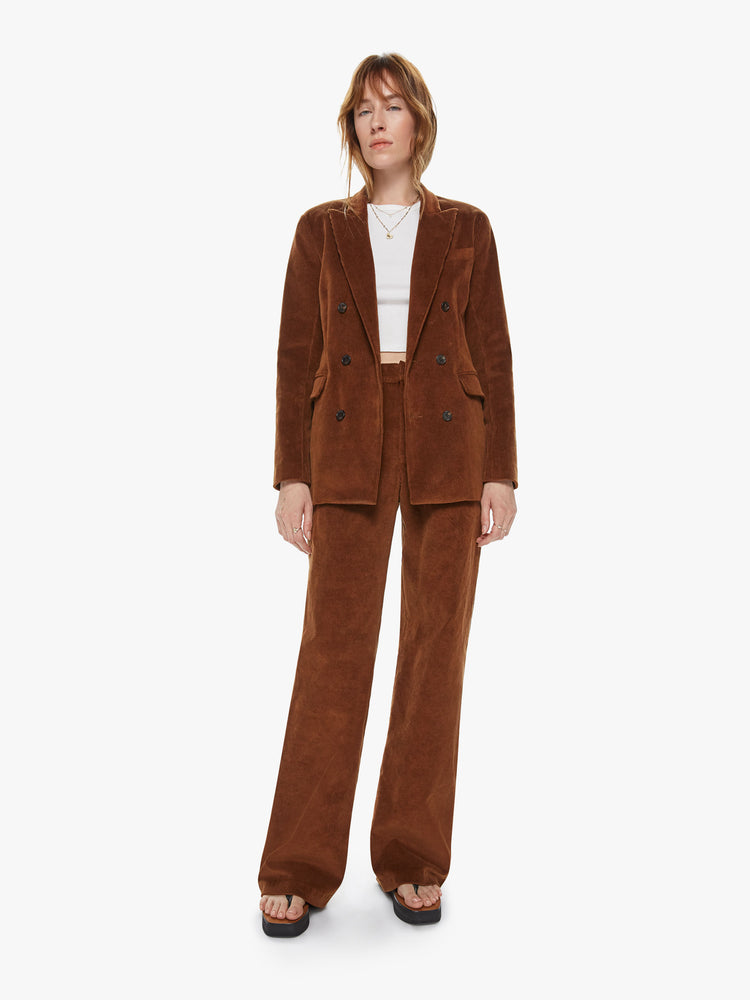 Front full body view of a woman wearing a brown corduroy blazer featuring two flap pockets, shoulder pads and an oversized lapel. 