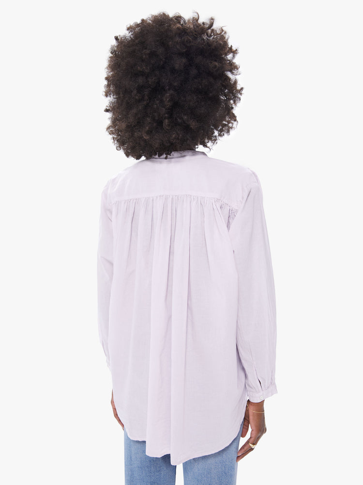 Back view of a women's lilac pastel colored blouse with long sleeves and a drawstring neck tie
