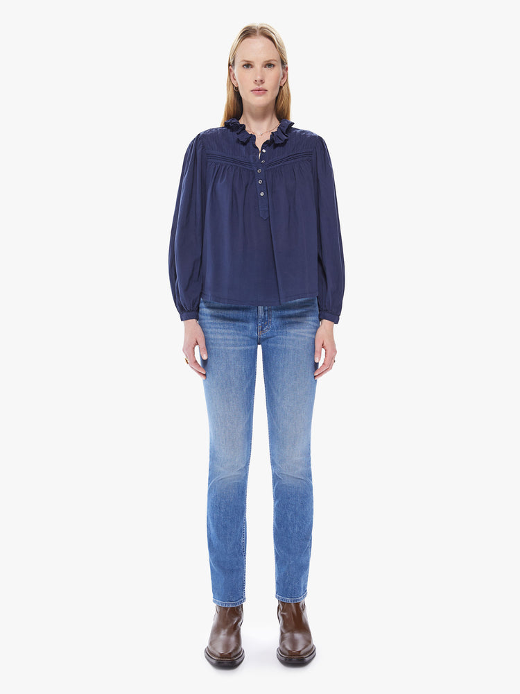 Full front view of a women's navy blue long sleeve blouse with a button-front placket and ruffle neckline