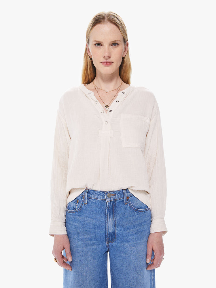 Front view of a women's ivory colored long sleeve shirt with a snap button front placket and patch pocket