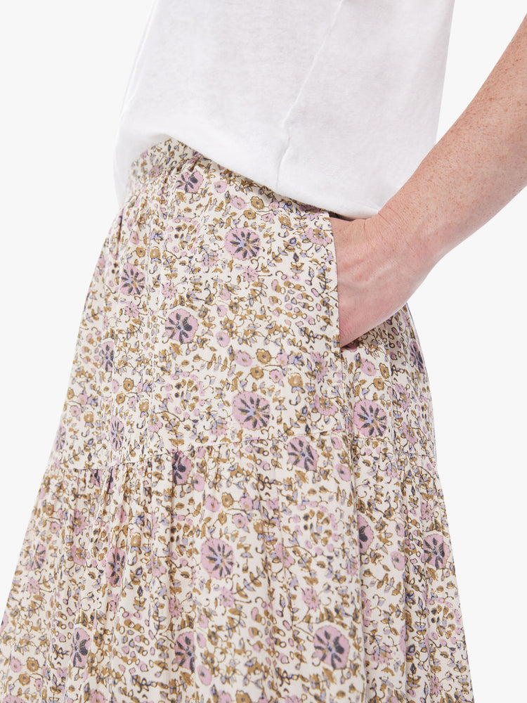 Pocket detail view of a women's cream colored midi skirt with an all-over pink and yellow floral print