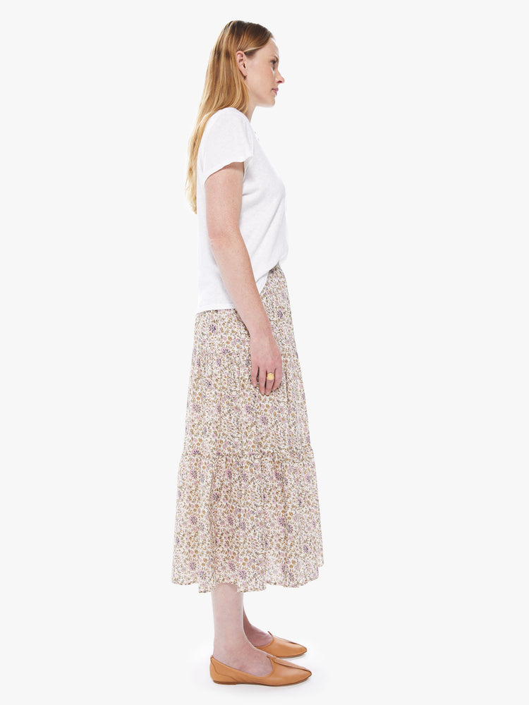 Side view of a women's cream colored midi skirt with an all-over pink and yellow floral print