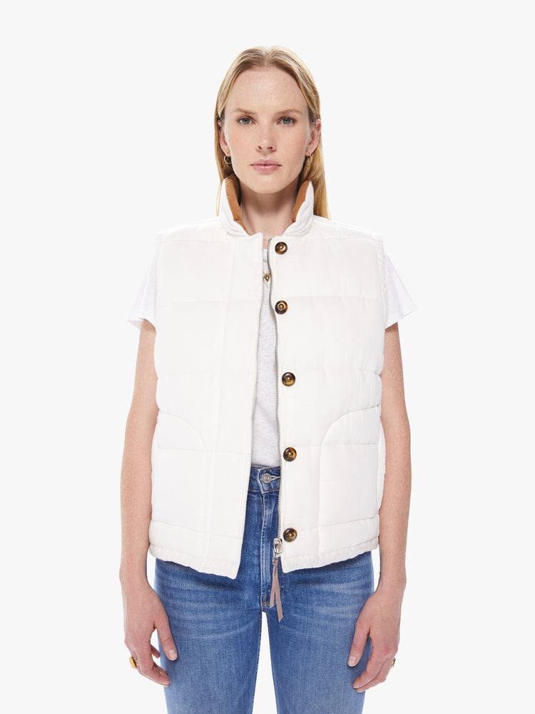 Front view of a women's ivory reversible vest with beige floral lining and tortoise buttons