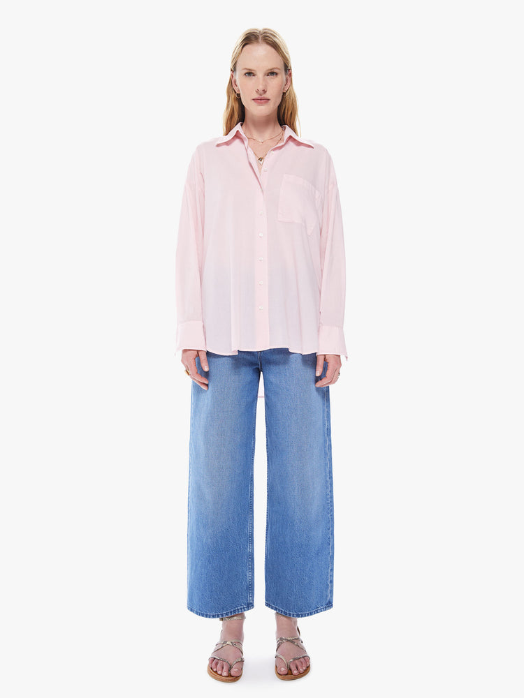 Front full body view of a women's light pink button down shirt featuring long sleeves, a single chest pocket, and an oversized fit.