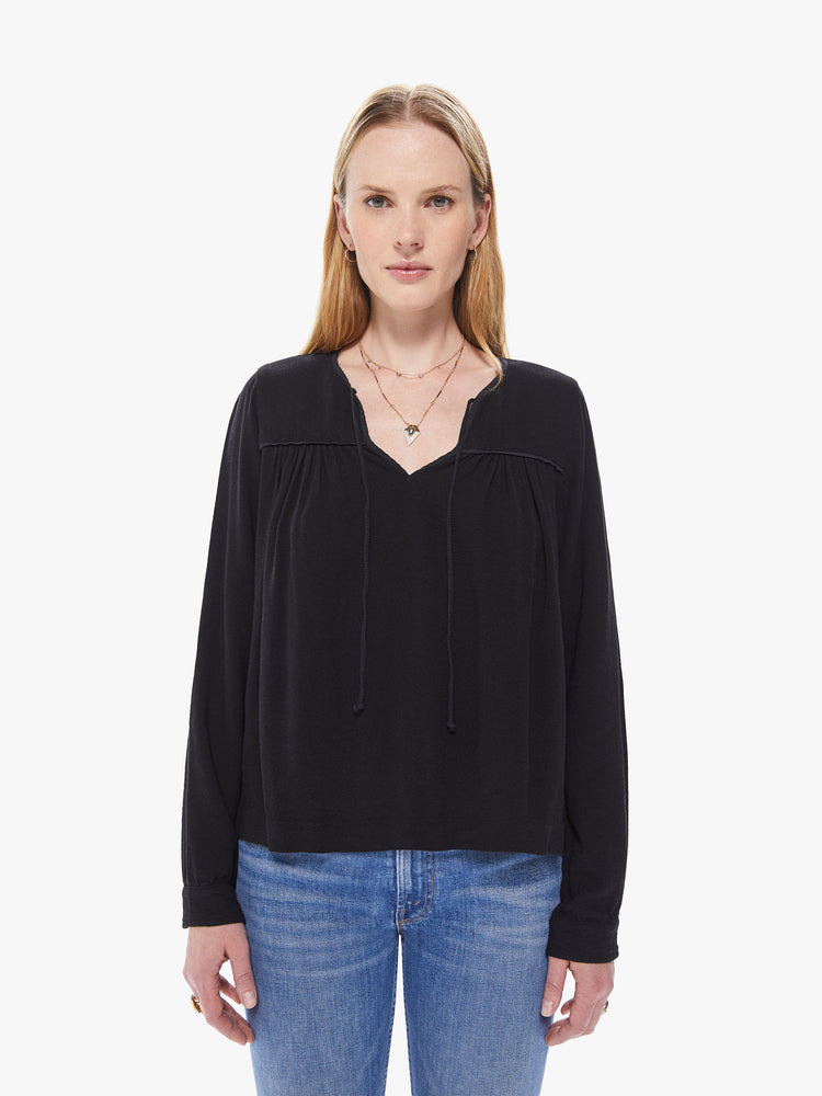 Front view of a women's black long sleeve blouse, featuring a flowy fit and a keyhole neck with tie.