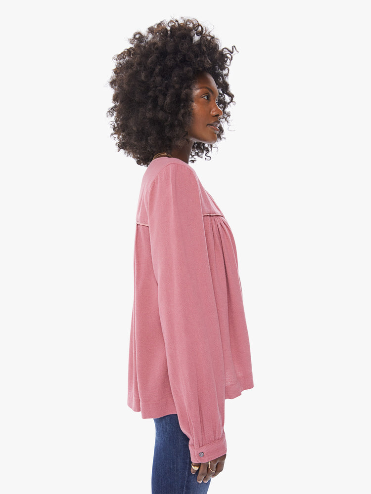 Side view of a women's deep pink long sleeve blouse, featuring a flowy fit and a keyhole neck with tie.