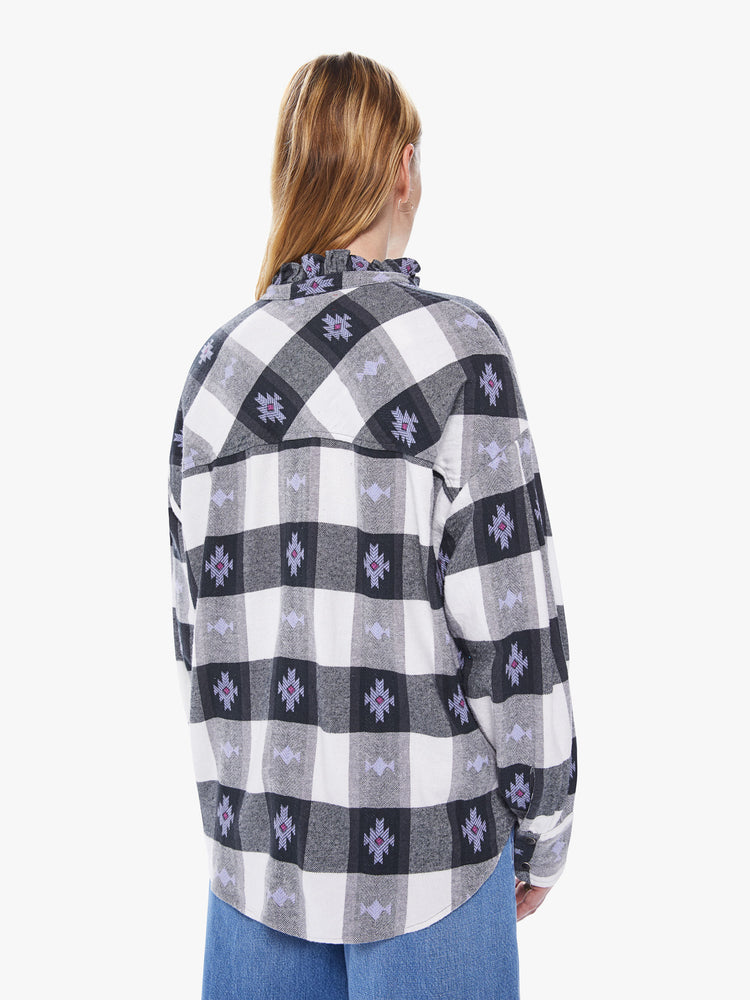Back view of a women's long sleeve button down featuring a ruffled collar, a black and white gingham print with purple details, and a loose oversized fit.