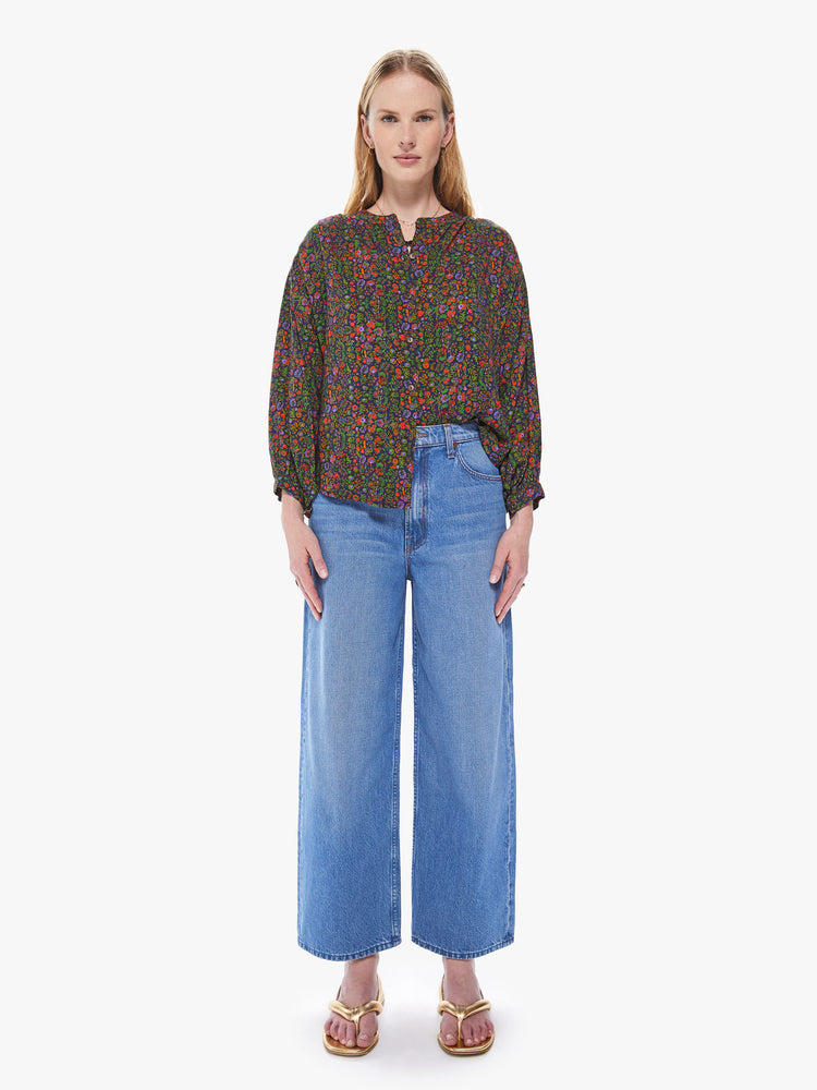 Front full body view of a women's button down blouse featuring a colorful floral print, a crew neck collar, billow sleeves, and a loose fit.