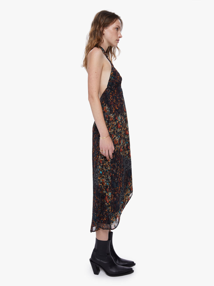 Side view of a womens dark printed dress featuring a a halter neck and an empire waist.