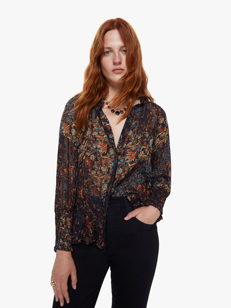 Front view of a womens dark printed button down blouse featuring loose long sleeves with smocked cuffs and a flowy fit.