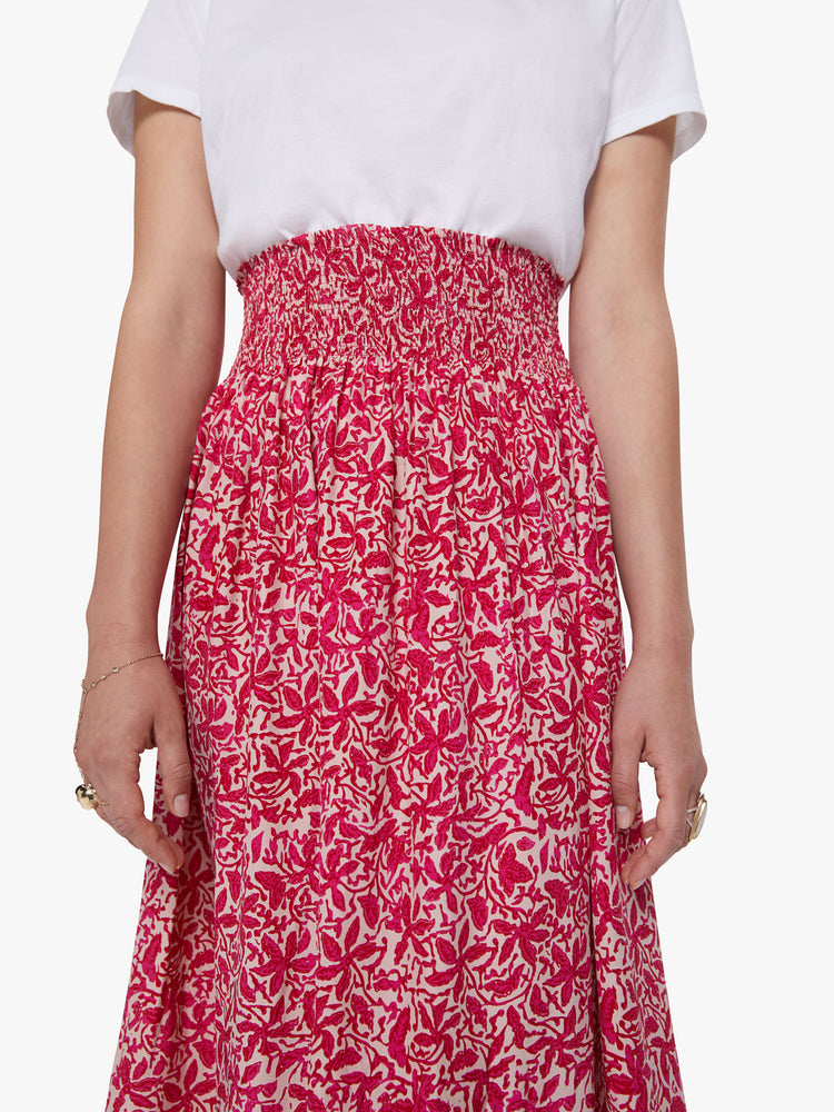 Waist line close up view of a woman wearing a floral maxi skirt with a smocked waistband and loose flowy fit