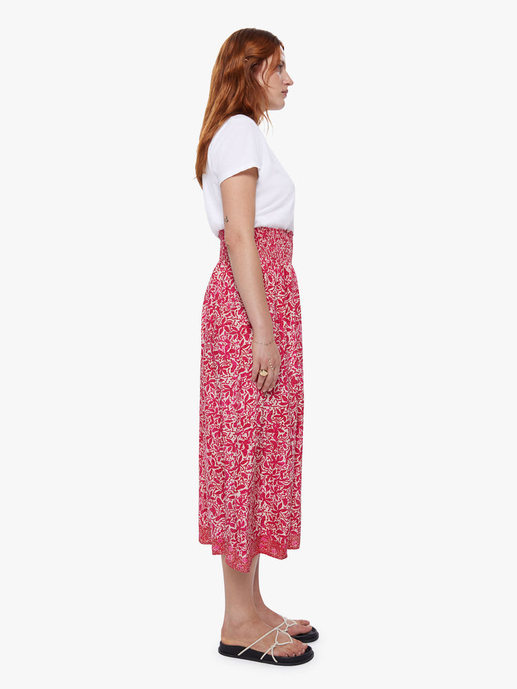 Side view of a woman wearing a floral maxi skirt with a smocked waistband and loose flowy fit