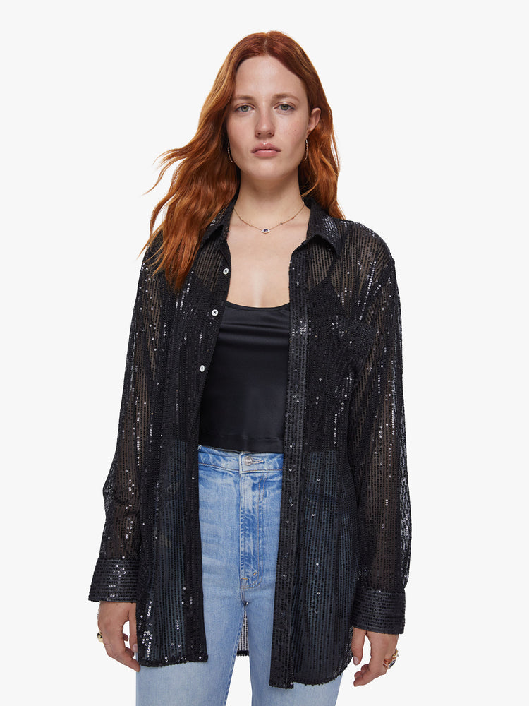 Front view of a womens sheer button down shirt featuring shiny black sequins and a loose flowy fit.