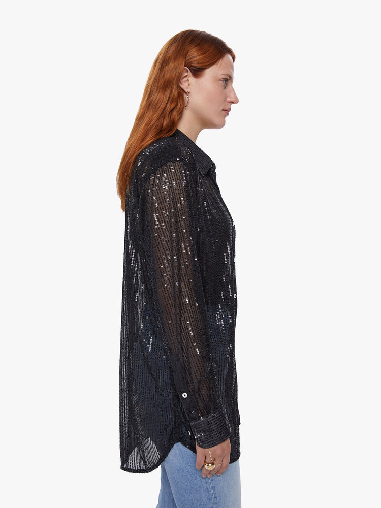 Side view of a womens sheer button down shirt featuring shiny black sequins and a loose flowy fit.