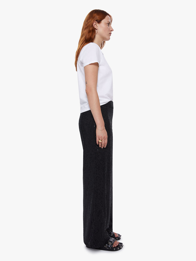 Side view of a womens wide leg pants featuring black sequins, a high rise, and a flowy fit.
