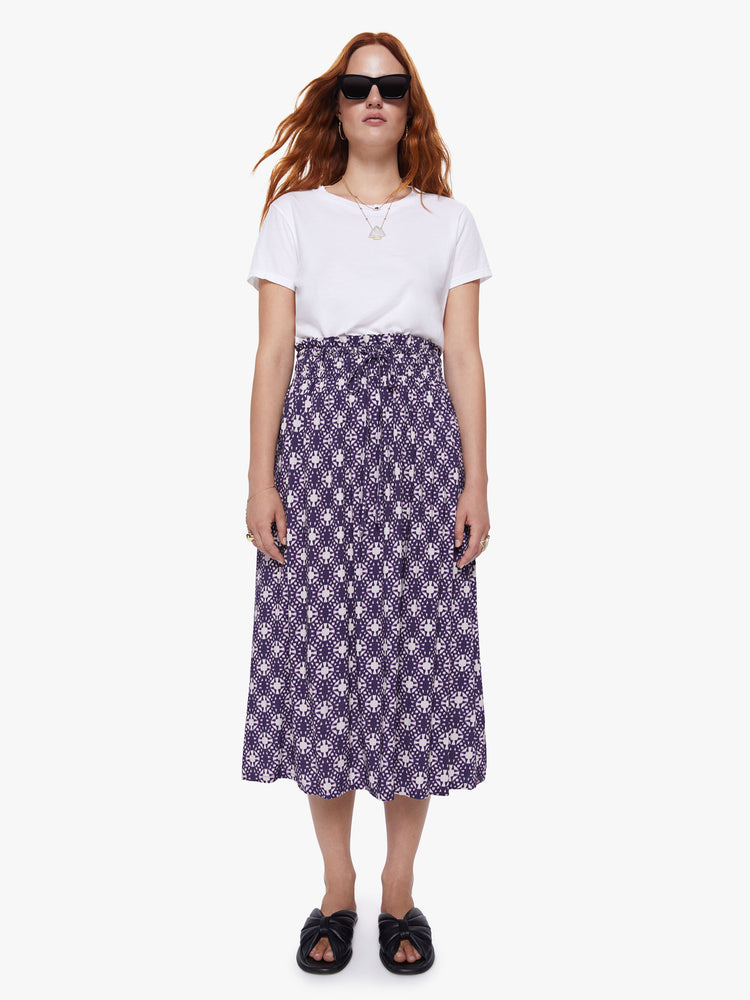Front view of a womens mid length skirt featuring a purple and white print, a rouched high waist, and a flowy fit.