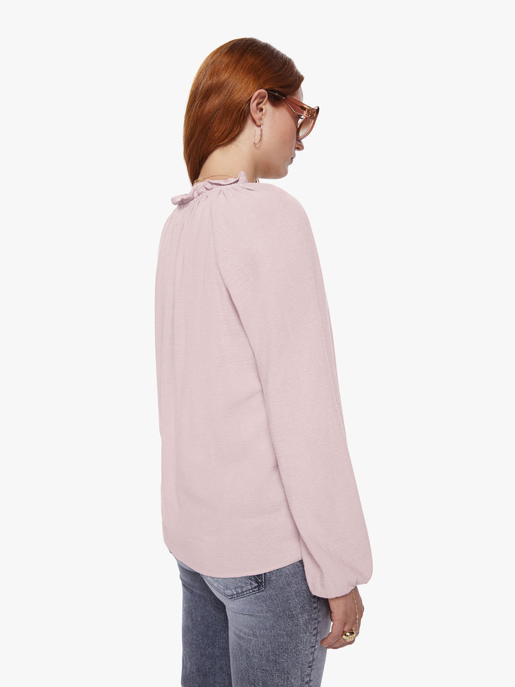 Back view of a womens pink v neck blouse featuring a ruffled collar, billow sleeves, and a flowy fit.