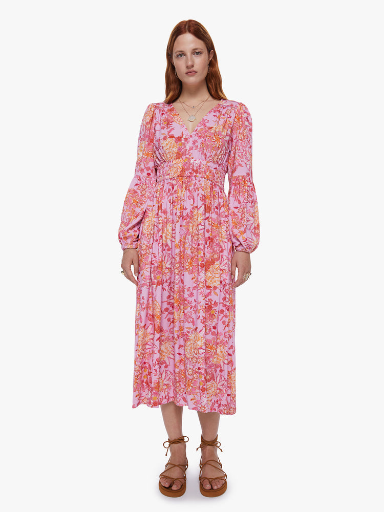 Front view of a womens midi pink and orange floral dress, featuring long billow sleeves a rouched waist and v neck.