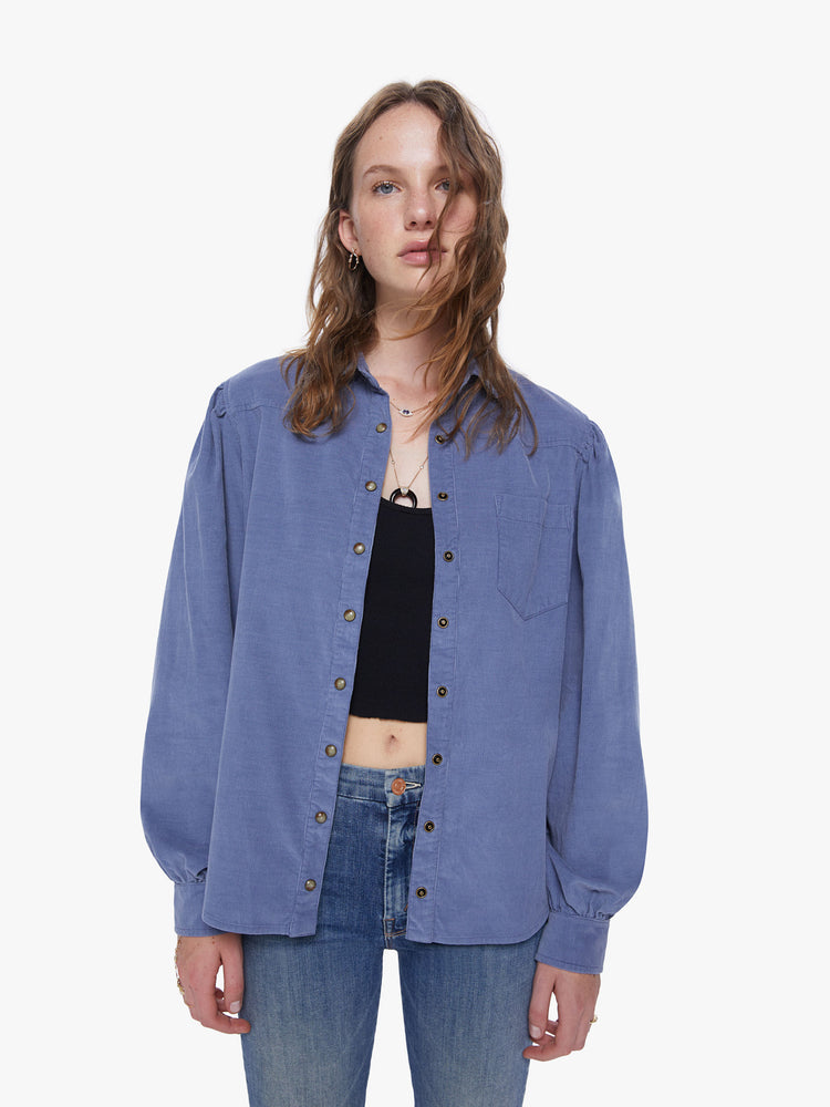 Front view of a womens blue button down shirt, featuring a chest pocket and long billow sleeves.