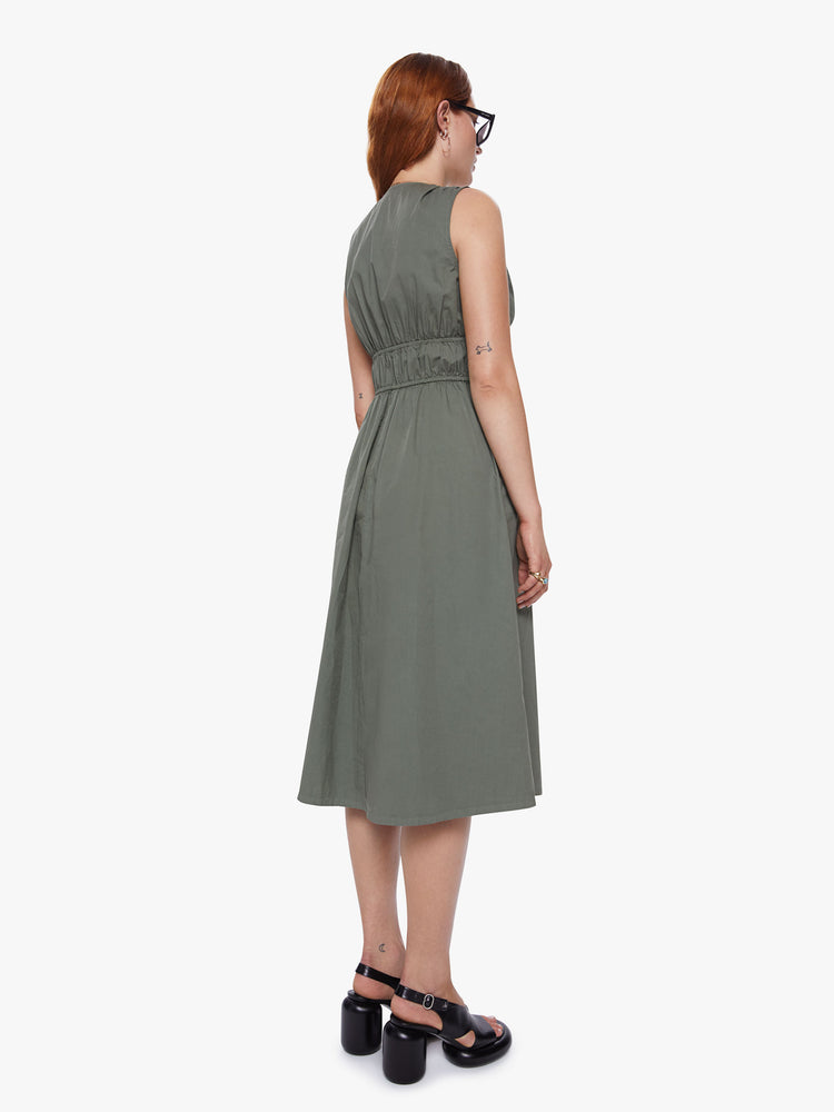 A back view of a woman wearing an olive green midi dress with a deep v neckline