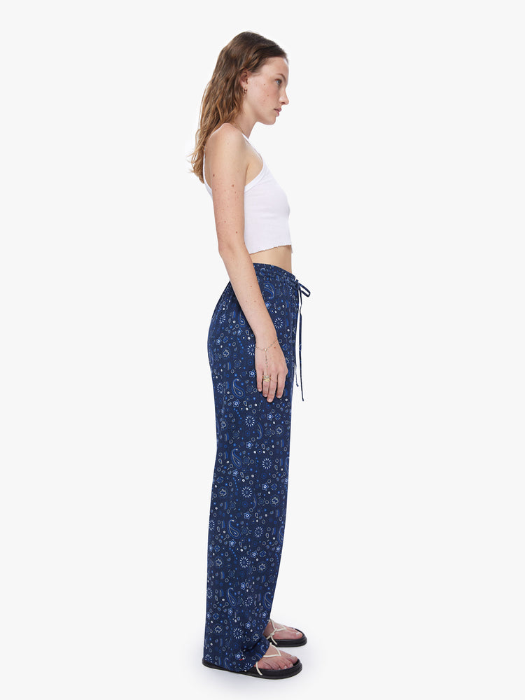 A side view of a woman wearing a navy blue pant with paisley print