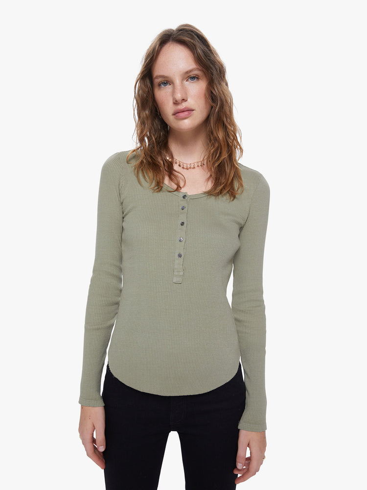 A front view of a woman wearing a green, long sleeve henley top