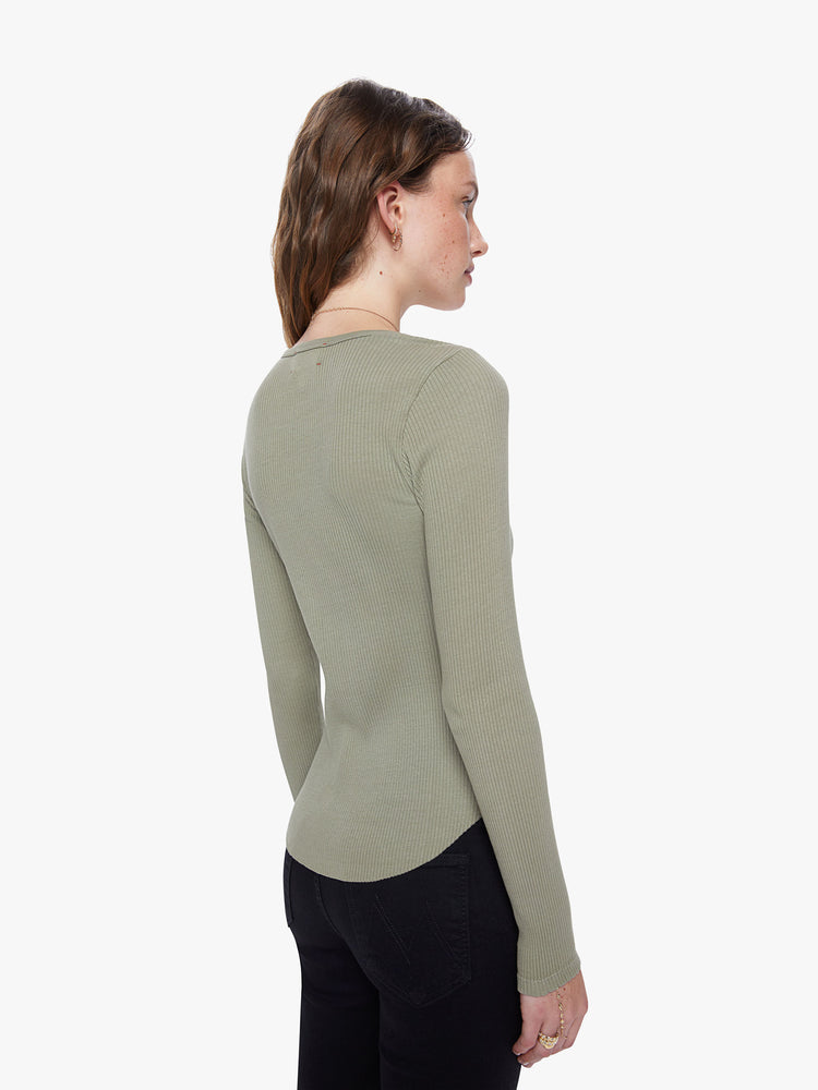 A back view of a woman wearing a green, long sleeve henley top