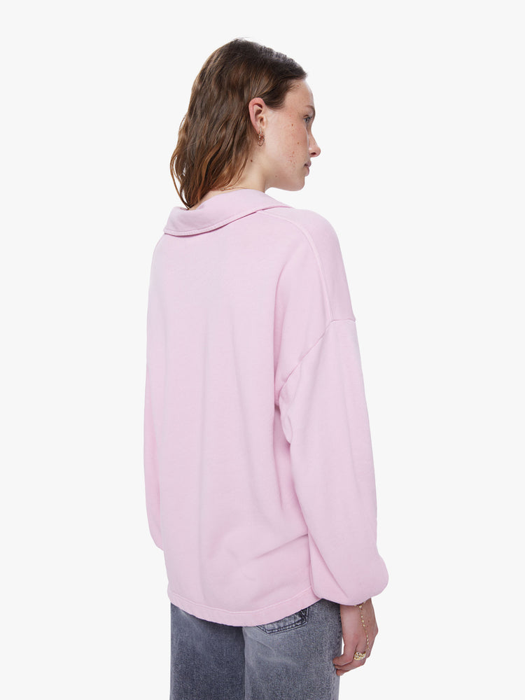 A back view of a woman wearing a light pink sweatshirt with a deep v, collared neckline