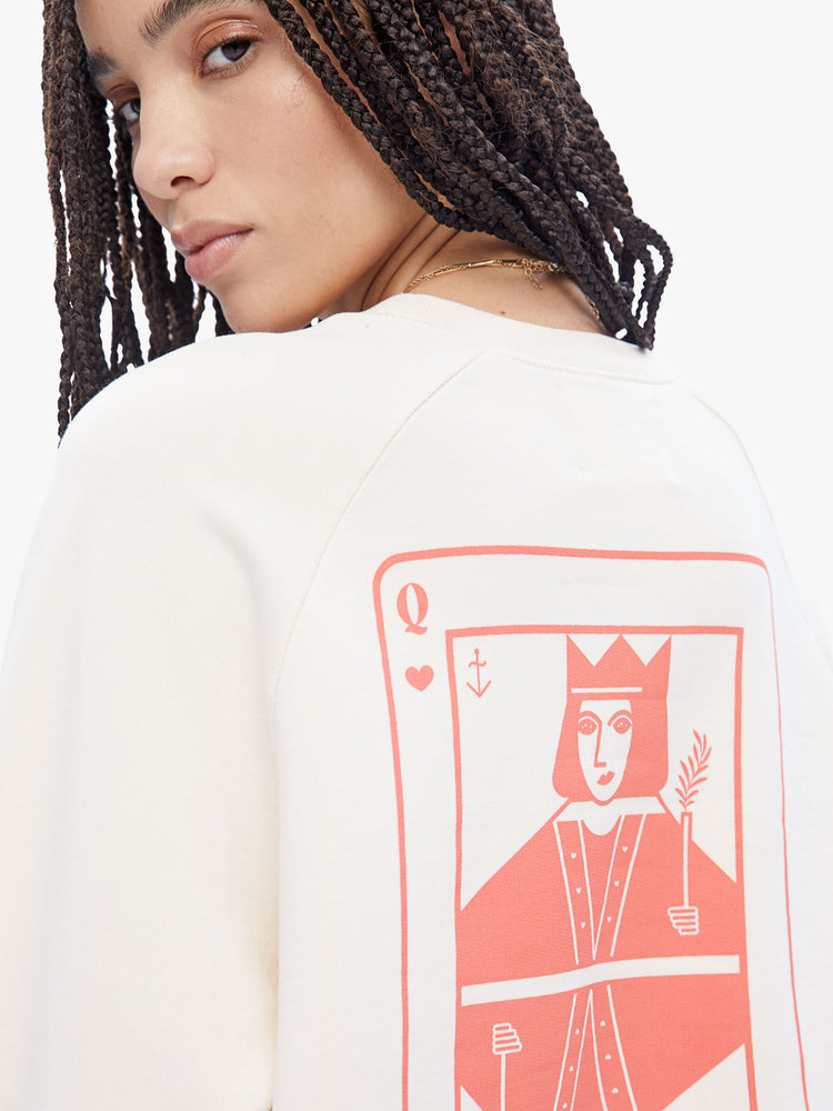 Close up back view of a woman in a timeless La Paz classic sweatshirt, this cream sweatshirt has a relaxed shape with raglan sleeves and is decorated with a Queen of Hearts in peach on the back.