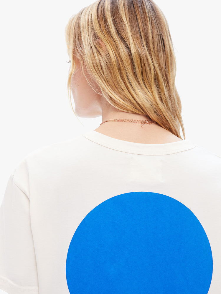 Close up back view of a woman in classic tee from La Paz, the white classic crewneck tee features the brands logo on the front and a blue circle on the back