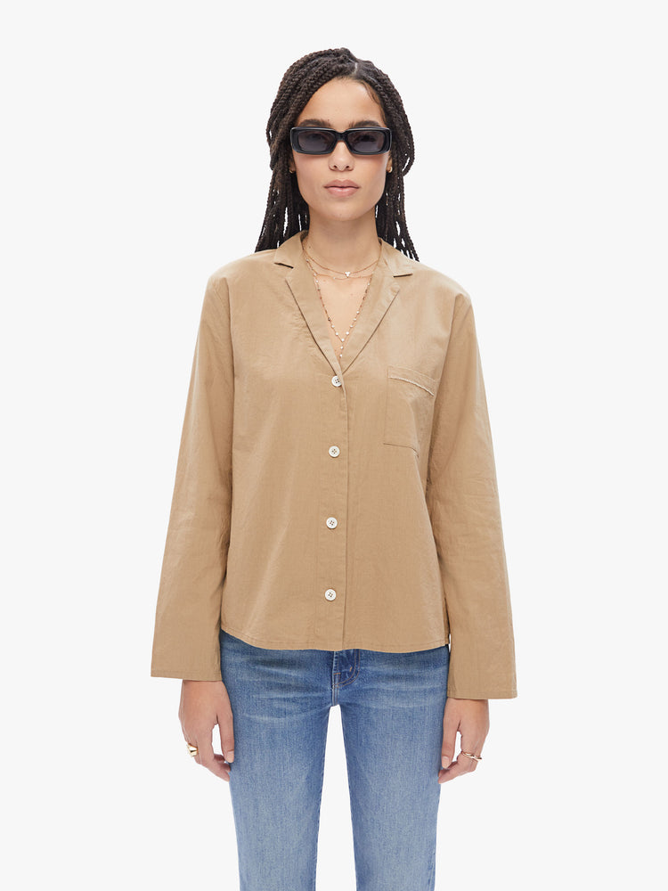Front view of a woman in a French brand Elsa Esturgie , this long sleeve top is designed with a vneck, notched collar, buttons down the front and long sleeves made from 100% Organic cotton in a camel hue