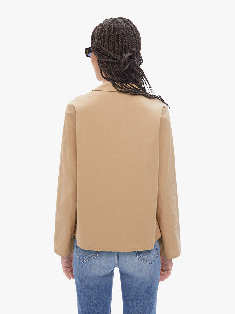 Back view of a woman in a French brand Elsa Esturgie , this long sleeve top is designed with a vneck, notched collar, buttons down the front and long sleeves made from 100% Organic cotton in a camel hue