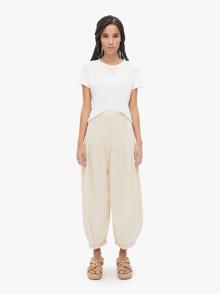 Front view of a woman in Elsa Esturgie a French brand, these wide-leg balloon pants have a gathered waistband, side pockets, elastic hems and voluminous fit in a 100% organic cotton cream hue