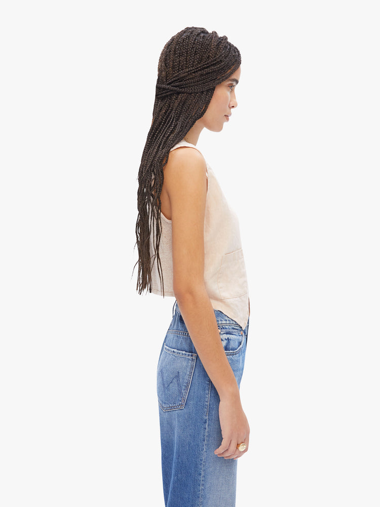 Side view of a woman in Elsa Esturgie a French brand that uses natural fabrics, the intact vest is designed with a Vneck, buttons down the front and a cropped, angle in an off-white hue made from linen and recycled cotton blend