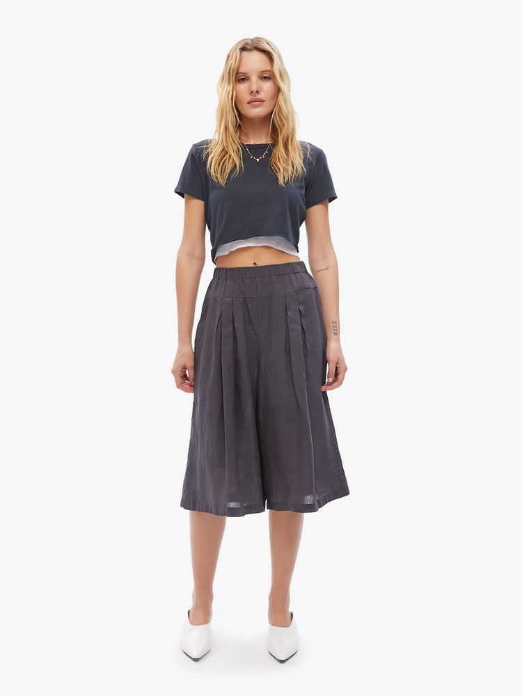 Front view of a woman in Elsa Esturgie uses natural fabrics, these wide-leg capri pants have a high rise gathered waistband, side pockets and an airy feel made from 100% linen in a dark grey hue