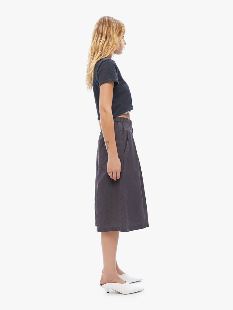 Side view of a woman in Elsa Esturgie uses natural fabrics, these wide-leg capri pants have a high rise gathered waistband, side pockets and an airy feel made from 100% linen in a dark grey hue