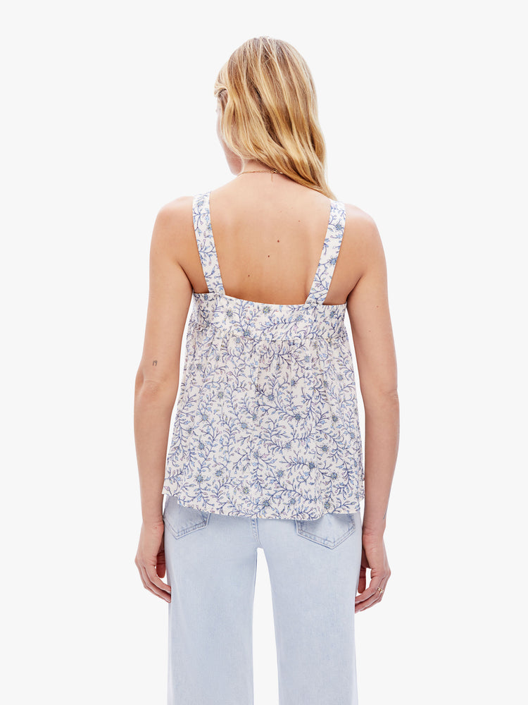 Back view a woman in an effortless tank from XiRENA that has a V-neck that ties, thick straps and ruffles at the front for a loose, flowy fit in a delicate floral print