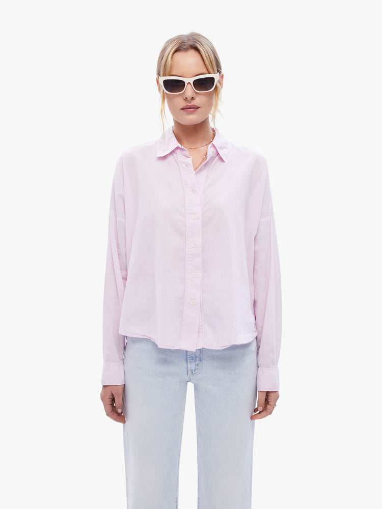 Front view of a woman in a light pink button down from XiRENA, the long sleeve shirt is light, airy with a loose fit, drop shoulders and a hip-grazing hem