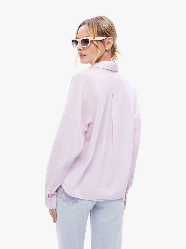 Back view of a woman in a light pink button down from XiRENA, the long sleeve shirt is light, airy with a loose fit, drop shoulders and a hip-grazing hem