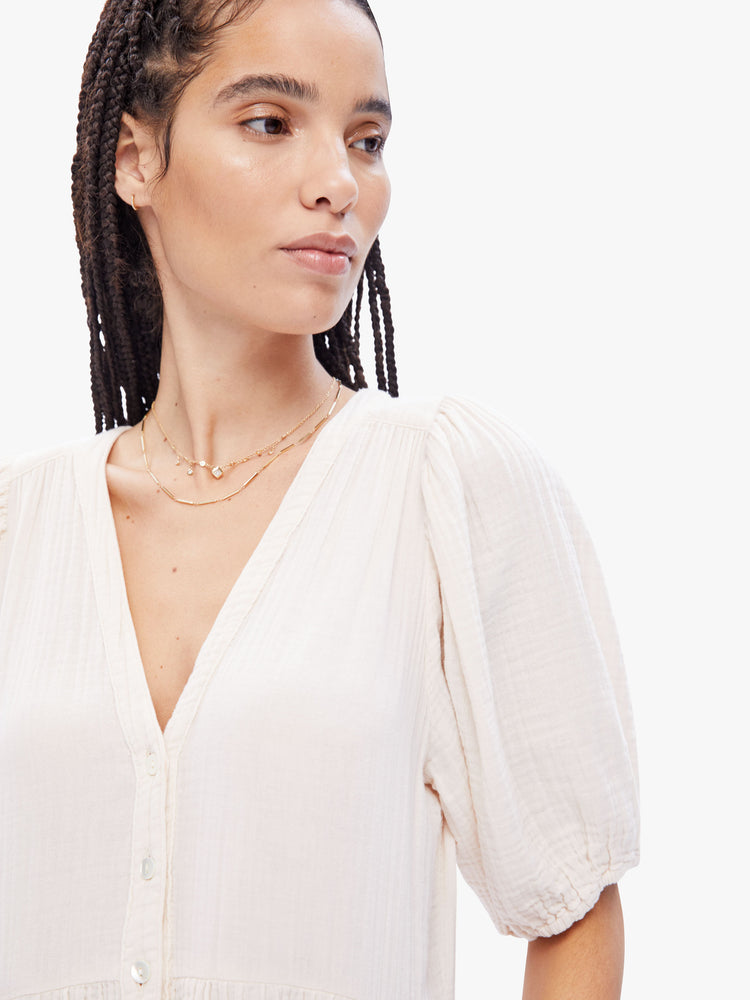 Close up view of a woman in a maxi dress from XiRENA, the dress features a Vneck, short balloon sleeves and flowy tiered skirt in an off- white hue