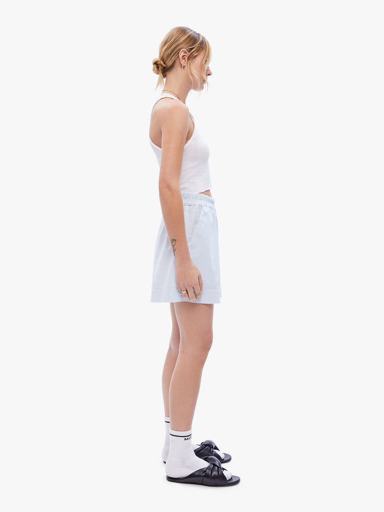Side full body view of a woman in easy shorts from XiRENA, in a blue stripe pattern designed with a high rise, elastic waist and a loose, boxy fit