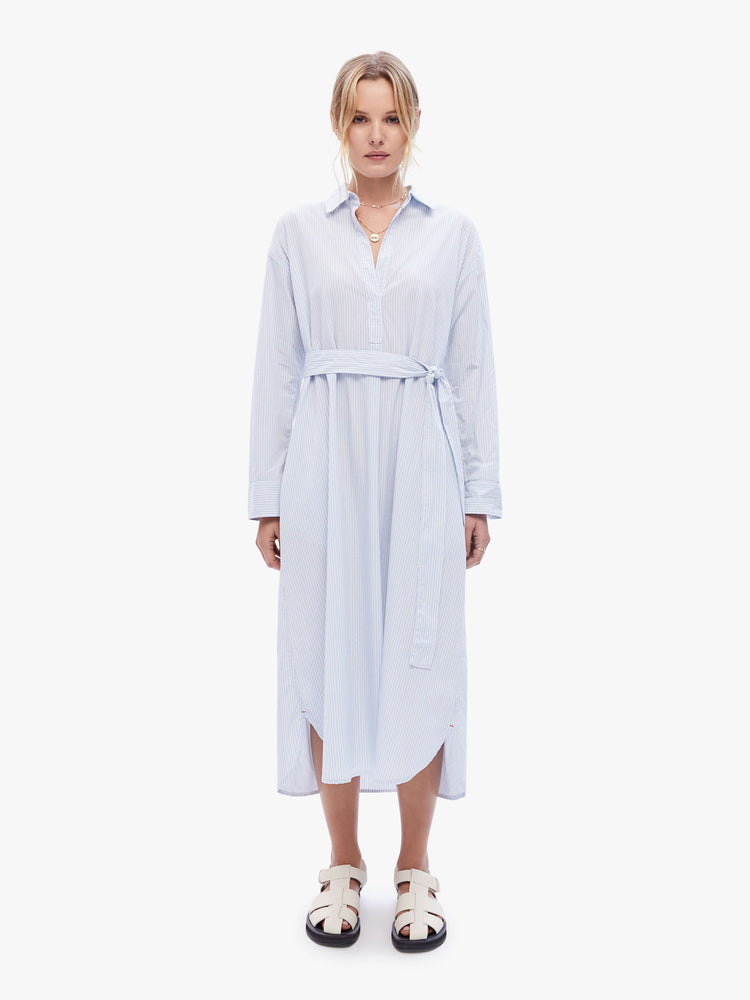 Front full body view of a woman in a effortless dress from the California inspired line by XiRENA in a sky blue pattern featuring a collared V-neck, long loose sleeves, a tied waist and side slits
