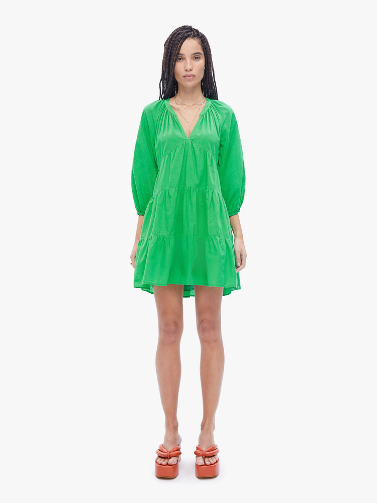Front full body view of woman in a mint green hue dress that features a gathered v-neck, 3/4 length balloon sleeves and a tiered skirt that hits mid-thigh 